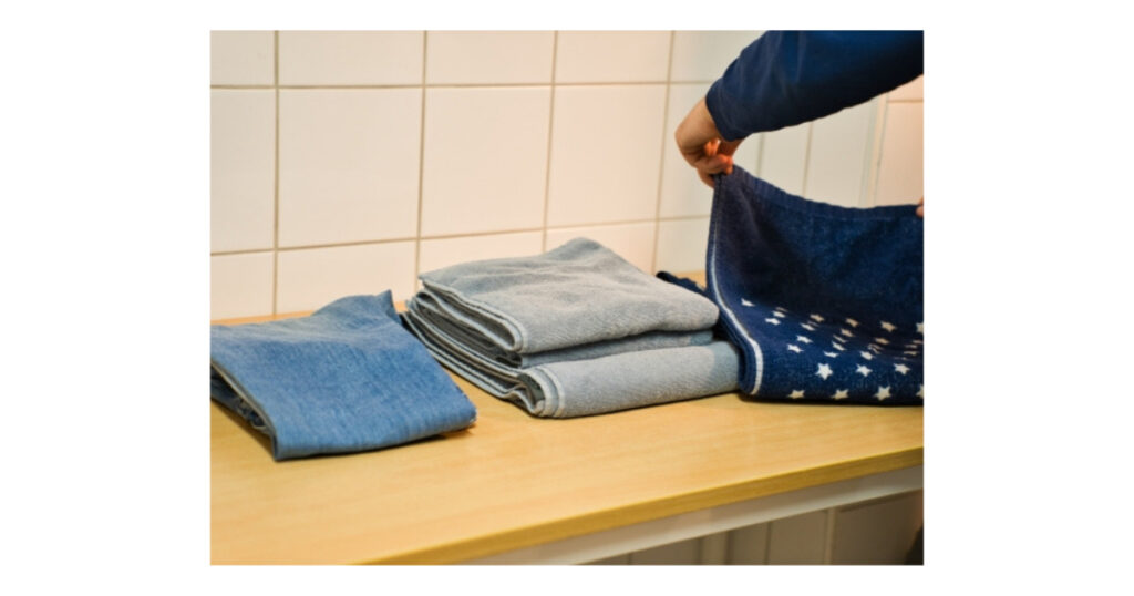 洗濯物をカウンターで畳んでいる男性の手